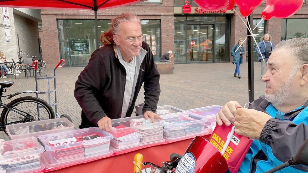 Kai-Uwe Jesiek (links) am Wahlkampfstand der Linken spricht mit einem Besucher in Leer. Foto: Nording