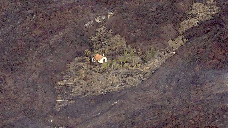 Der Vulkanausbruch auf der kleinen Kanaren-Insel La Palma hat Hunderte Häuser zerstört - eines ist jedoch wie auf wundersame Weise verschont geblieben. Foto: Emilio Morenatti/AP Pool/dpa