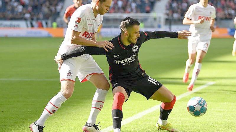 Frankfurts Filip Kostic (r) schirmt den Ball vor Kölns Benno Schmitz ab. Foto: Arne Dedert/dpa