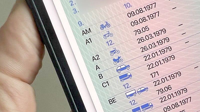 Ein Mann hält ein iPhone mit der App „ID Wallet“, in der die digitale Variante eines Führerscheins zu sehen ist. Foto: Christoph Dernbach/dpa