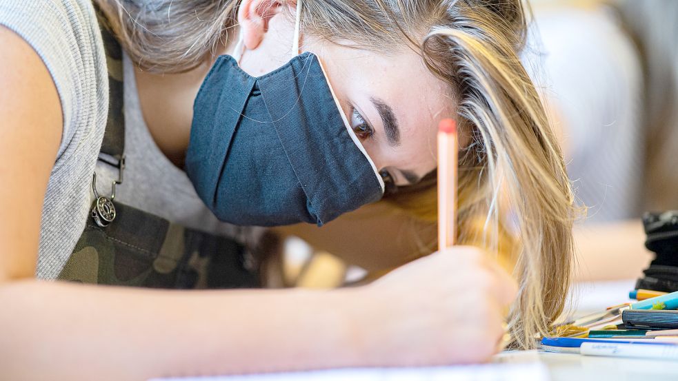 Schülerin mit Corona-Schutzmaske im Unterricht an einer Gesamtschule: Der Lehrerverband und die GEW fordern eine Beibehaltung der Maskenpflicht. Einzelne Länder haben aber bereits anders entschieden. Foto: Kirchner/dpa