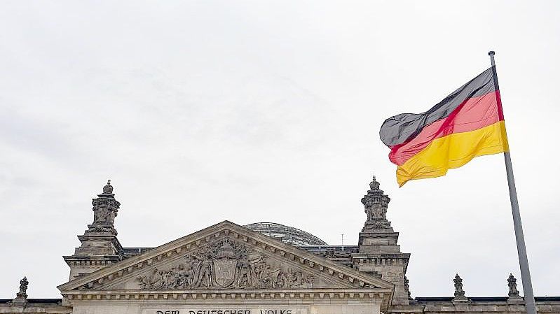 Eine Deutschland-Fahne weht am Tag der deutschen Einheit vor dem Reichstag. Die Ära der Volksparteien ist aus Sicht des Präsidenten der Bundeszentrale für politische Bildung, Thomas Krüger, absehbar beendet. Foto: Paul Zinken/dpa