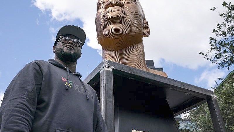Terrence Floyd neben der Skulptur seines Bruders George Floyd. Foto: John Minchillo/AP/dpa