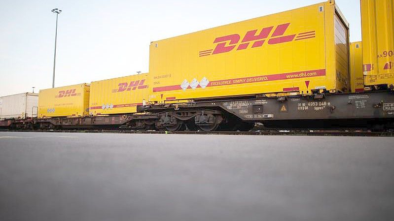 DHL-Container stehen im Güterterminal in Langerfeld auf Waggons. Foto: Jonas Güttler/dpa