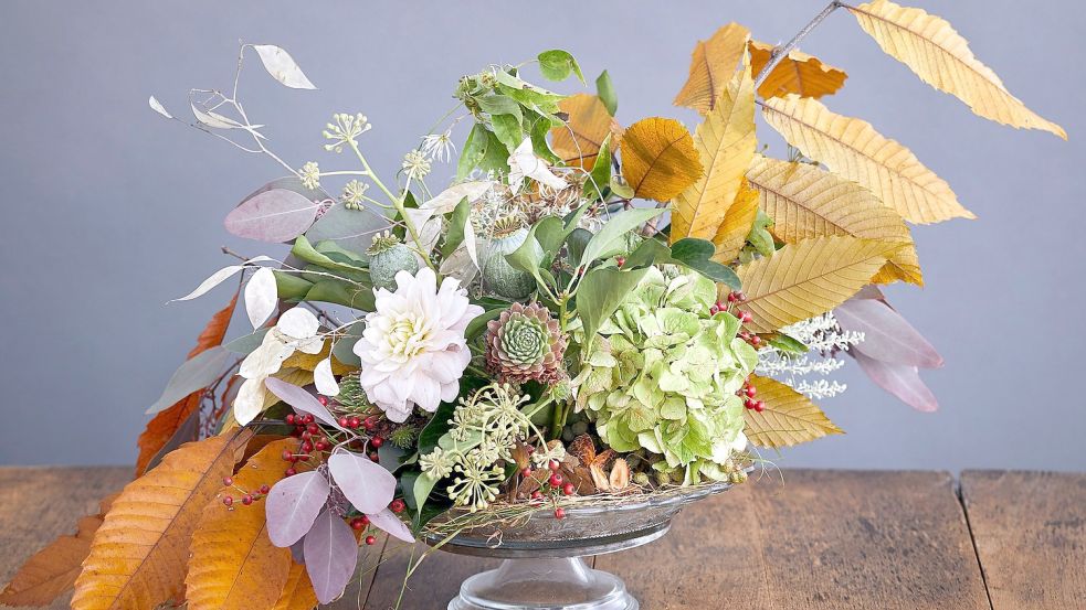 In einer Schale lassen sich herbstliche Blätter und Blumen leicht in Steckschaum dekorieren. Foto: Landgard
