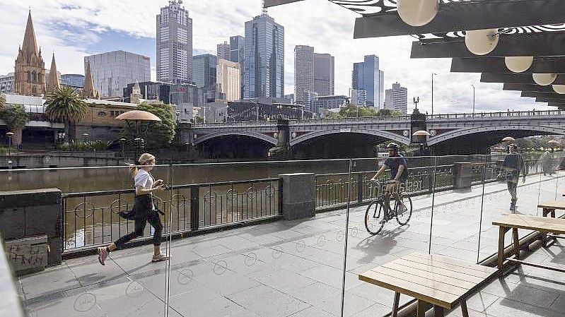 Menschen joggen entlang der Southgate in Melbourne. Gut eineinhalb Jahre nach Beginn der Corona-Pandemie hat die australische Millionenmetropole einen unrühmlichen Rekord aufgestellt: 246 Tage im Lockdown-Modus. Foto: Daniel Pockett/AAP/dpa