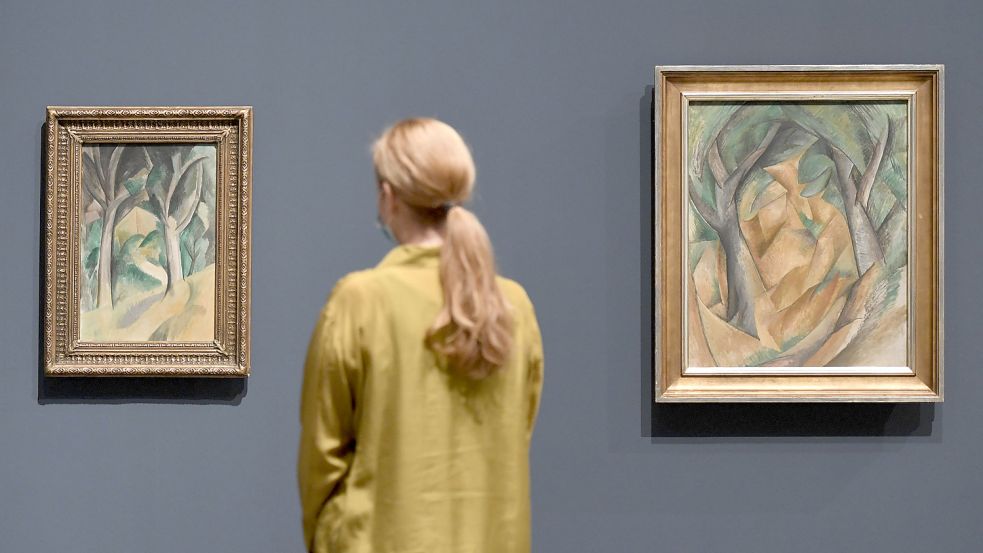 Kubismus in Düsseldorf: Eine Frau betrachtet die Bilder „Bäume, 1908“ (l) und „Die Bäume, 1908“ von Georges Braque in der Kunstsammlung NRW. Foto: Roberto Pfeil/dpa Foto: Roberto Pfeil