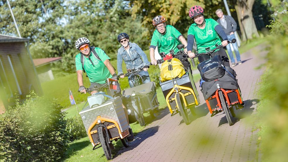 Helmut Beckmann (links), Lothar Harberts (Zweiter von rechts) und Monika Loers kamen nach rund 620 Kilometern Fahrtstrecke in Aurich an. Dort wurden sie vom Leiter der Ortsgruppe der Schokofahrer, Holger Wessels (Zweiter von links), empfangen. Foto: Ortgies