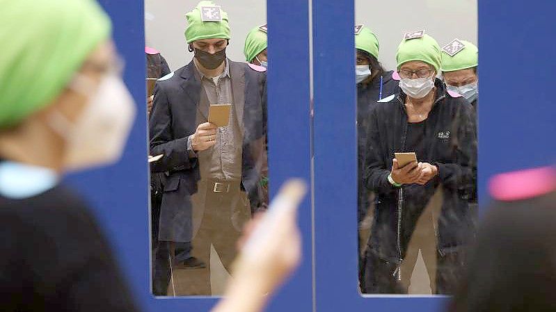 Probanden, mit grünen Mützen und Punkten zur Kameraerfassung markiert, simulieren im Rahmen eines Fußgänger-Experiments den Ein- und Ausstieg am Bahnsteig. Foto: Oliver Berg/dpa