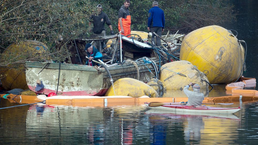 Ein Kanute macht Bilder von dem mit Hebesäcken gehobenen Fahrgastschiff „Moornixe“. Foto: Gambarini/DPA