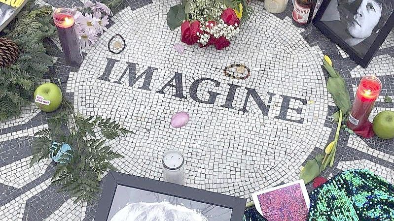 Fotos, Blumen und Kerzen an der Gedenkstätte „Strawberry Fields“ in New Yorks Central Park. Foto: Mark Lennihan/AP/dpa