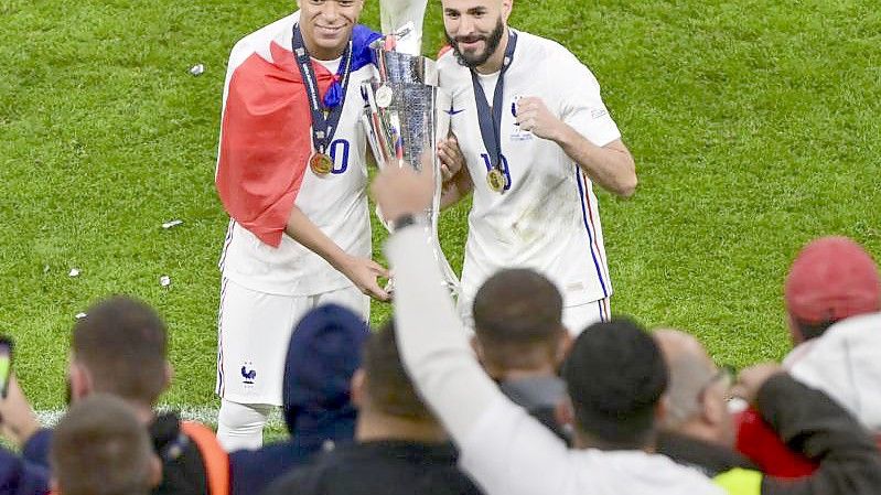 Kylian Mbappé (l) und Karim Benzema feiern den Gewinn der Nations League. Foto: Miguel Medina/Pool AFP via AP/dpa