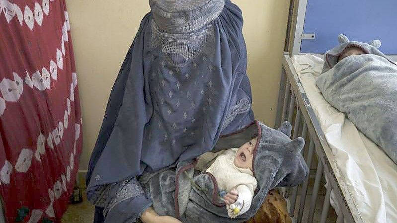 Eine Frau hält eines ihrer beiden Babys, die in Kabul behandelt werden, auf dem Arm. Foto: Felipe Dana/AP/dpa