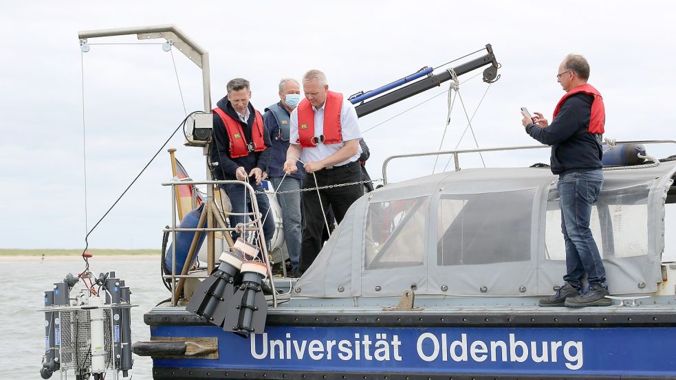 Der niedersächsische Wissenschaftsminister Björn Thümler lässt mit Prof. Dr. Oliver Zielinski (links) von der Uni Oldenburg vier Drifter ins Wasser. Sie werden von der Strömung transportiert und lassen sich über GPS per App verfolgen. Foto: Böning