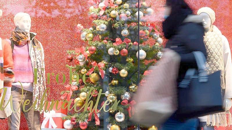 Eine Passantin geht mit einer Papiertüte auf einer Einkaufsstraßeentlang. (Archivbild). Foto: Sebastian Kahnert/dpa-Zentralbild/dpa