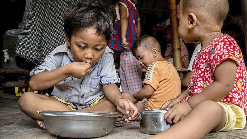 Kinder einer vom World Food-Programme unterstützten Familie sitzen beim Mittagessen in ihrer Hütte im Hlaing Thar Yar Township. (Archivbild). Foto: Kaung Htet Lin/World Food Programme/dpa
