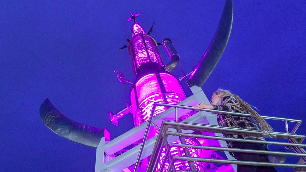 Rebecca Stark aus Moormerland steht auf dem pink angestrahlten Sous-Turm in Aurich. Foto: Ortgies