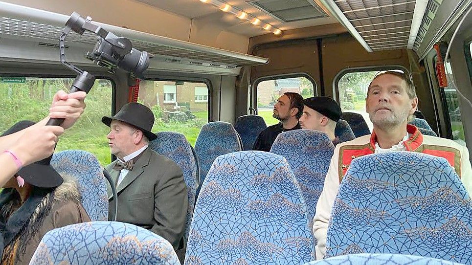 Wirt Enne Offers Buß (Heiko Janssen), Pastor Johann Heinrich Leiner (Gert-Mimke Köllmann), Jan Harms (Eike Henninga) und König Georg V. (Alfred Alberts) (von links) kommen als Zeitreisende in einem Bus in das heutige Mittegroßefehn und erkennen es kaum wieder. Foto: Privat