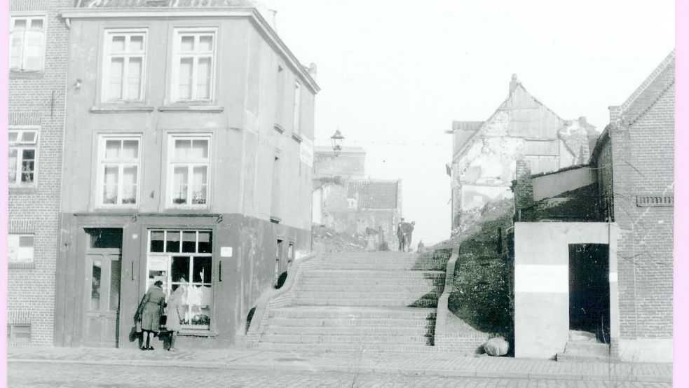 Ein Blick auf die Emstreppe Anfang des 20. Jahrhunderts: Links befindet sich der Bäcker Oltmanns, Im Hintergrund ist der Bunker Holzsägerstraße (heute Bunkermuseum) zu sehen. Oben an der Treppe fegt Peterke de Boer - als „Peterke“ bekannt - die Straße. Foto: Bildarchiv der Johannes-a-Lasco-Bibliothek