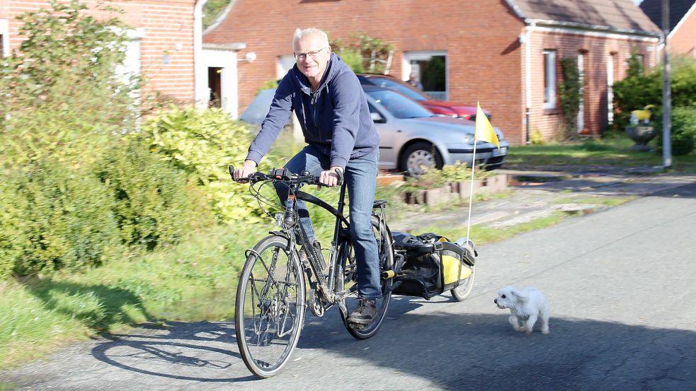 Holger Kleene zurück in Oldersum mit einem aufmerksamen Nachbarshund. Auf Reisen hat er am liebsten seinen Anhänger dabei. Der musste auf dem Weg zum Schwarzen Meer aber zu Hause bleiben. Foto: Böning