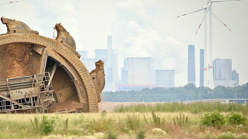 Der Schaufel eines Braunkohlebaggers baggert im Tagebau Garzeiler; im Hintergrund stehen eines der RWE-Kraftwerke und daneben Windräder. Während die Energiepreise steigen, will die COP26 in Glasgow sich dem Klimawandel stellen. Foto: David Young/dpa