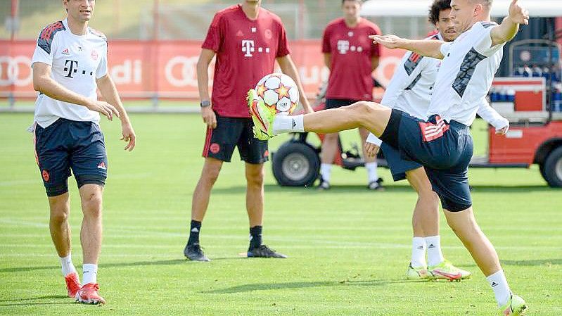 Bayerns Joshua Kimmich (r), Leroy Sane (hinten) und Thomas Müller halten den Ball hoch. Co-Trainer Dino Toppmöller beobachtet das Warm-Up. Foto: Matthias Balk/dpa