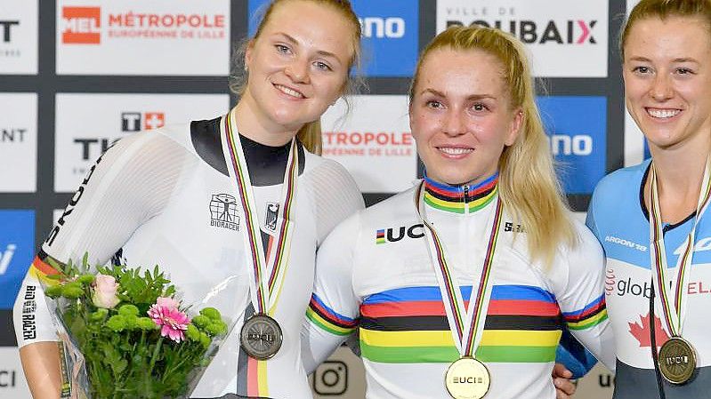 Wieder zusammen auf dem Podium: Emma Hinze (M) und Lea Sophie Friedrich (l). Foto: Denis Charlet/AFP/dpa