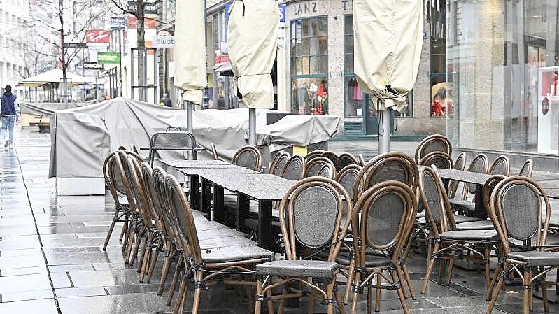Zusammengestellte Tische und Stühle stehen in einer Fußgängerzone Wiens. (Archivbild). Foto: Hans Punz/APA/dpa