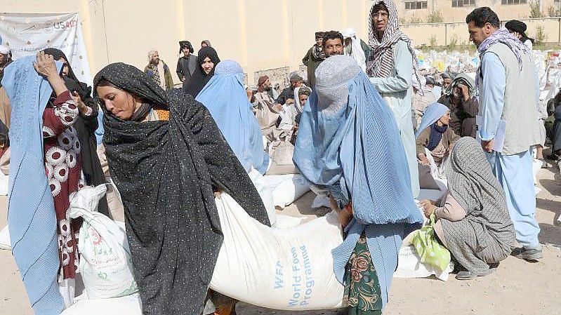 Frauen verlassen eine Verteilungsstelle des Welternährungsprogramm WFP am Stadtrand von Herat mit Lebensmittelrationen. Foto: Marco Di Lauro/WFP/dpa