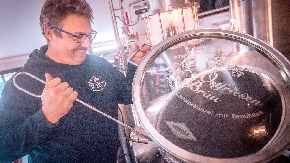 Brauerei-Chef René Krischer nimmt eine Probe aus einem der Kessel. Foto: Cordsen