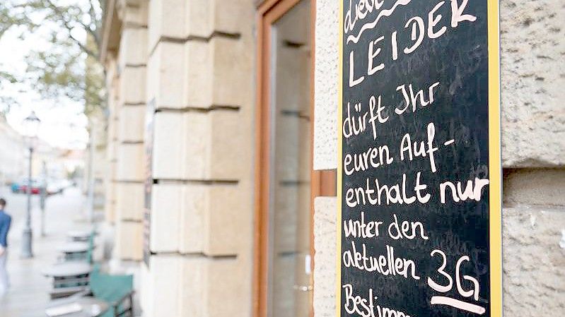 Eine Tafel vor einem Café in Dresden informiert Gäste über die 3G-Regel. Foto: Sebastian Kahnert/dpa-Zentralbild/dpa