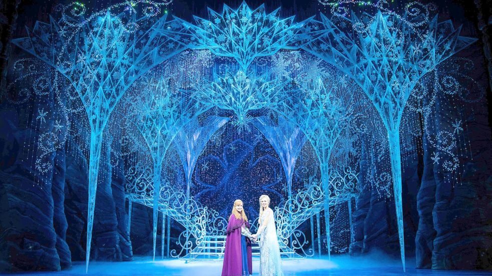 Frostig schön: Sabrina Weckerlin als Eiskönigin Elsa (rechts) und Celena Pieper als Anna posieren im Bühnenbild des Musicals „Die Eiskönigin“ fürs Foto. Foto: Christian Charisius/dpa