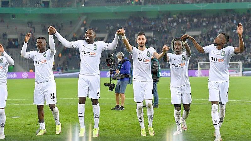 Mönchengladbachs Spieler feiern ihren Sieg. Foto: Marius Becker/dpa