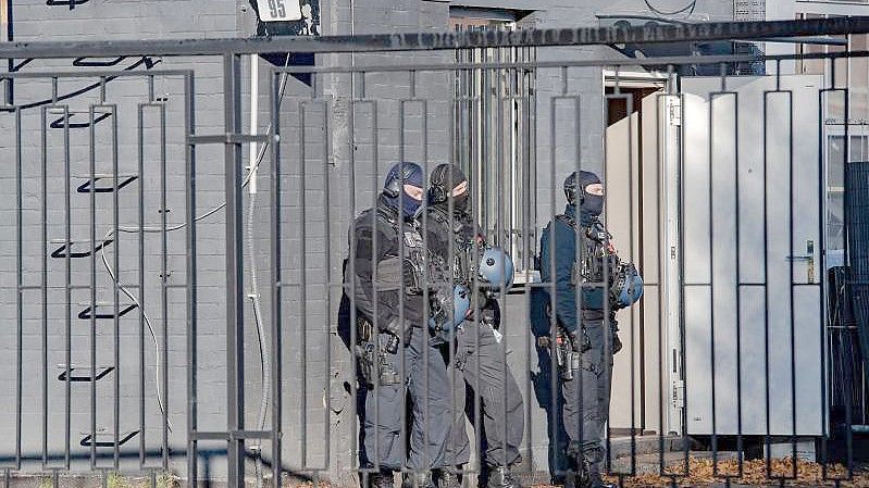 Polizeibeamte vor einem Gebäude in einem Gewerbegebiet in Berlin-Weißensee. Seit dem frühen Morgen wird gegen die Hells Angels in Berlin und Brandenburg vorgegangen. Foto: Paul Zinken/dpa