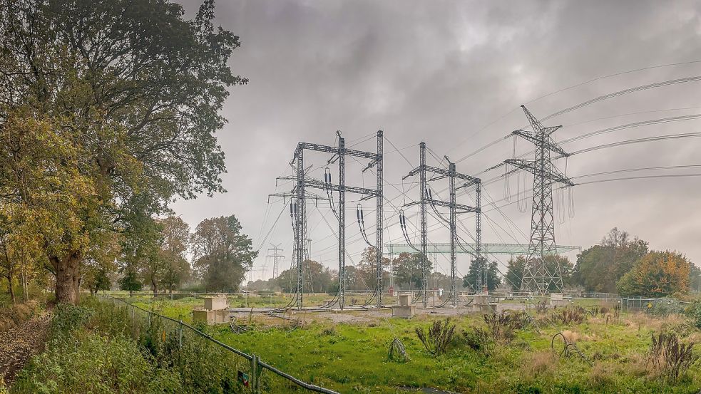 Die Kabelübergabestation an der B 436 in Strackholt. Hier wird die Freilandleitung unterirdisch fortgeführt. Im Hintergrund sieht man das per Gerüst über die Bundesstraße gespannte Schutznetz und die alte Leitung. Deren Masten sollen alsbald abgebaut werden. Foto: Ortgies