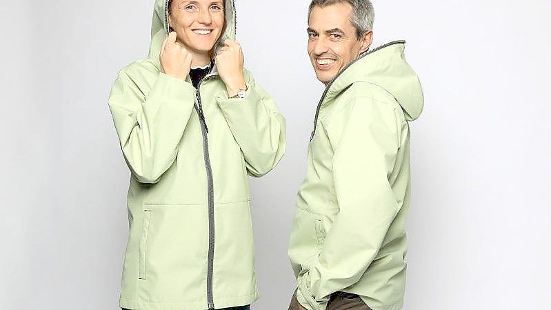 Annette Mark (l), Sprecherin von wear2wear, und Thomas Lehmann, Mitarbeiter der Firma Schoeller, in recycelten Regenjacken. Foto: -/Schoeller/dpa