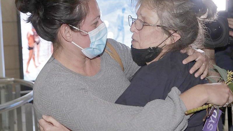 Eine Frau umarmt einem geliebten Menschen, nachdem sie mit einem Flug aus Los Angeles auf dem Flughafen von Sydney angekommen ist. Australien hat erstmals seit 20 Monaten wieder seine internationalen Grenzen für Staatsbürger und Menschen mit Wohnsitz in Down Under geöffnet. Foto: Rick Rycroft/AP/dpa