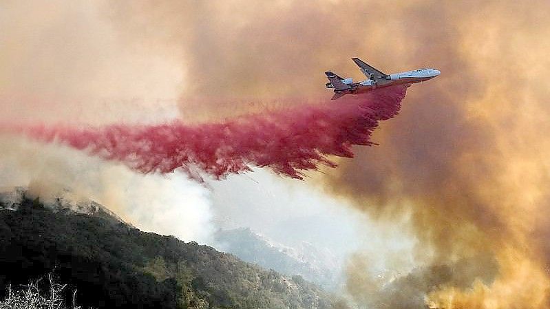 Ein Tankflugzeug wirft in Goleta, Kalifornien, Löschmittel auf einen Waldbrand ab. Das Alisal-Feuer erstreckte sich über mehr als 22 Quadratmeilen (57 Quadratkilometer) in den Santa Ynez Mountains westlich von Santa Barbara. Foto: Ringo H.W. Chiu/AP/dpa