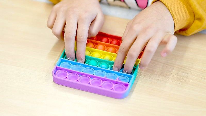 In einem Klassenzimmer einer Bielefelder Grundschule spielt ein Kind mit Pop-Its. Foto: Guido Kirchner/dpa