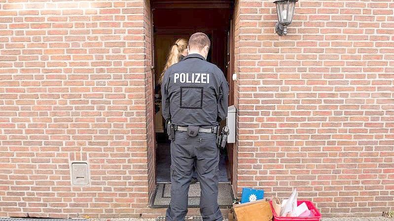 Einsatzkräfte vor einem Wohnhaus in Norderstedt. Objekte in Hamburg, Niedersachsen und Schleswig-Holstein wurden durchsucht. Foto: Daniel Bockwoldt/dpa