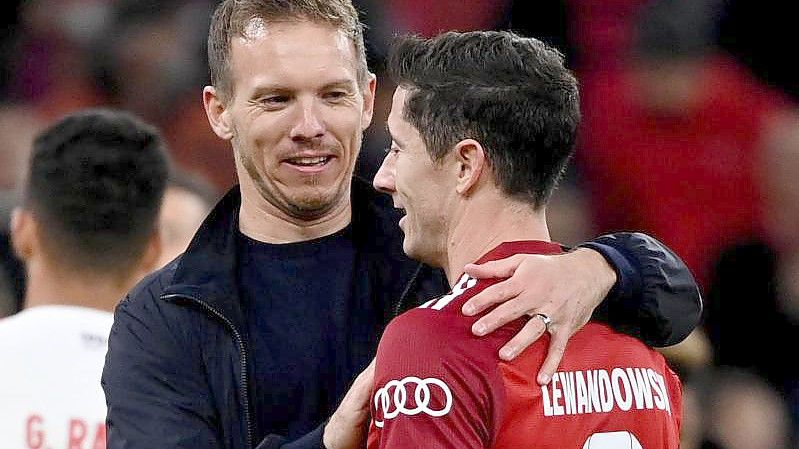 Bayern-Trainer Julian Nagelsmann (l) gratuliert Robert Lewandowski zum dessen drei Treffern. Foto: Sven Hoppe/dpa