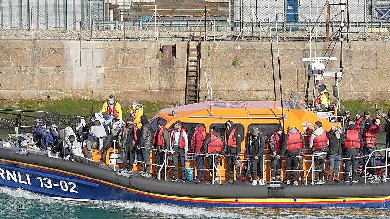 Eine Gruppe von Menschen, bei denen es sich vermutlich um Migranten handelt, wird von Grenzpolizisten nach Dover gebracht. Foto: Gareth Fuller/PA Wire/dpa