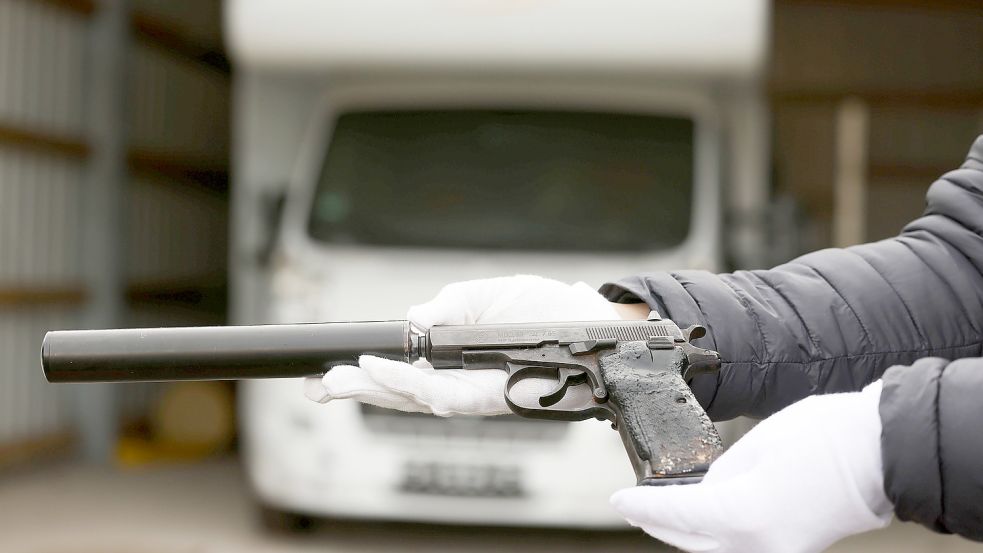 Ein Mitarbeiter des Bundeskriminalamtes hält eine der Tatwaffen des NSU, eine Pistole Ceska 83, 7.65 mm Browning mit Schalldämpfer, vor dem Wohnmobil der Terrorzelle in der Hand. Foto: Berg/dpa