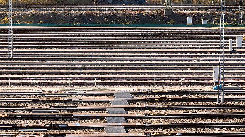 Eine rote Rangierlokomotiven fährt im Nordwesten der bayerischen Landeshauptstadt an den leeren Schienen eines Rangierbahnhof der Deutschen Bahn (DB) vorbei. Foto: Peter Kneffel/dpa