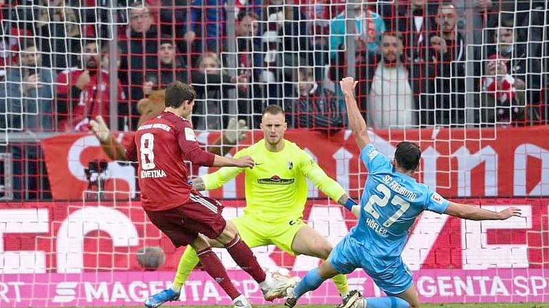 Leon Goretzka (l) brachte die Bayern gegen Freiburg in Führung. Foto: Sven Hoppe/dpa