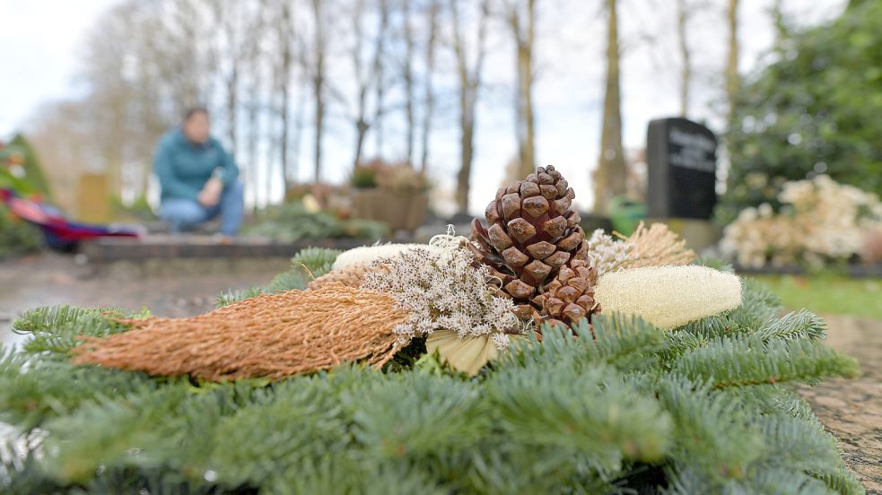 Grabgestecke werden meistens vor dem Totensonntag platziert. Farblich sollten sie zur übrigen Gestaltung und zum Stein passen. Foto: Ortgies