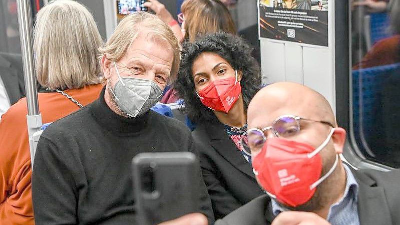 Der Regisseur Sönke Wortmann (l) nimmt an der Premiere des Films "Das Herz der Bahn" in einer S-Bahn teil und macht Selfies mit den Bahn-Mitarbeitern Emilie Lebon und Can Simsek. Foto: Jens Kalaene/dpa-Zentralbild/dpa
