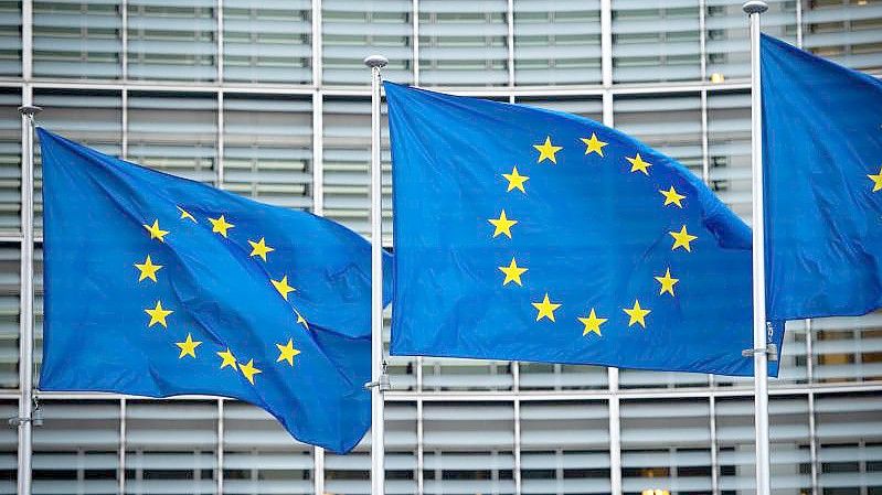 Flaggen der Europäischen Union wehen im Wind vor dem Berlaymont-Gebäude der Europäischen Kommission in Brüssel. Foto: Arne Immanuel Bänsch/dpa