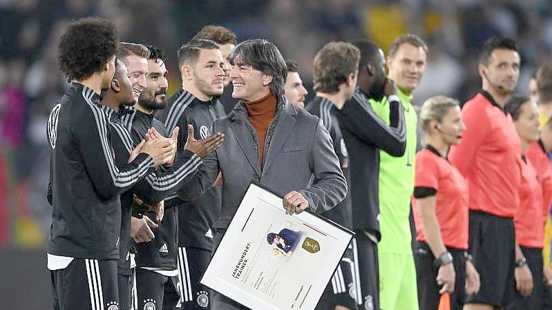 Der ehemalige Bundestrainer Jogi Löw (M) bedankt sich bei den Spielern, nachdem er eine Urkunde bekommen hat. Foto: Swen Pförtner/dpa