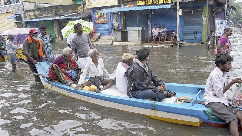 In Indien: Im Boot durch die überfluteten Straßen. Foto: R. Parthibhan/AP/dpa